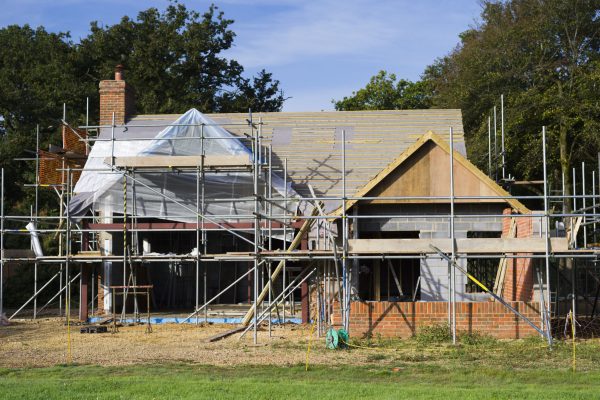 A family home under construction. A building site with scaffolding.
